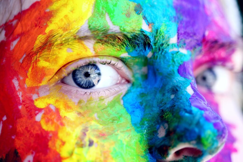 pexels-photo-1209843 Close-up of a person with colorful rainbow face paint, symbolizing LGBT pride and expression.