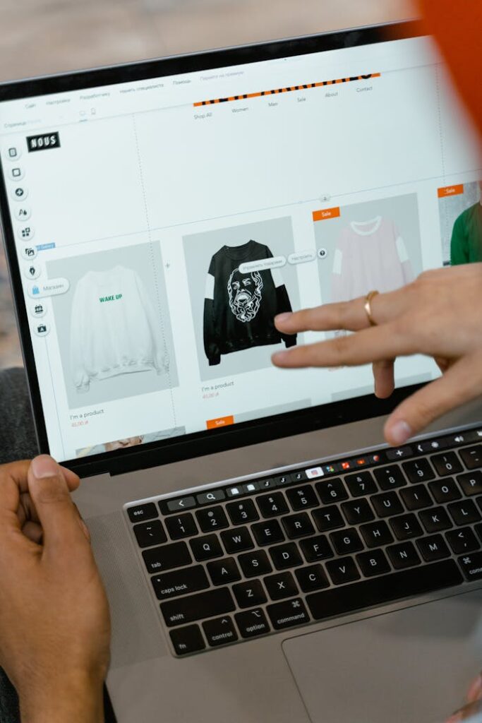 pexels-photo-7679865 Close-up of hands interacting with a shopping website on a laptop screen indoors.